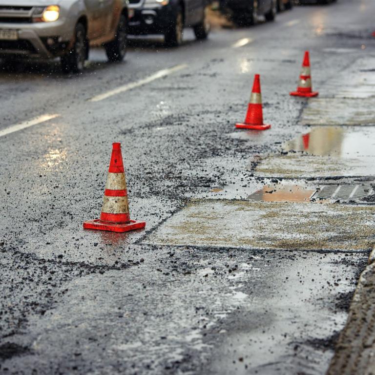 defekte Straße ist mit Pylonen gesichert